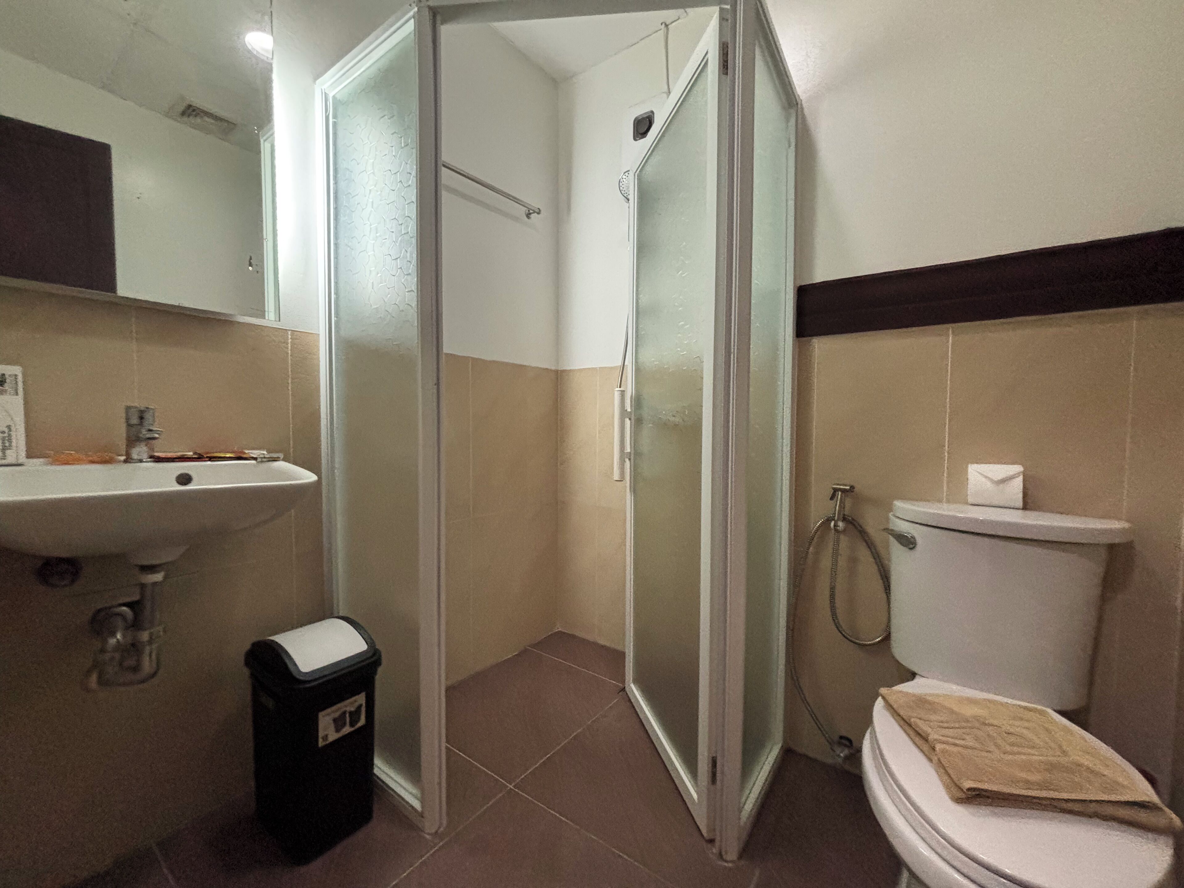 Un bagno con box doccia in vetro, un lavandino e un water.
