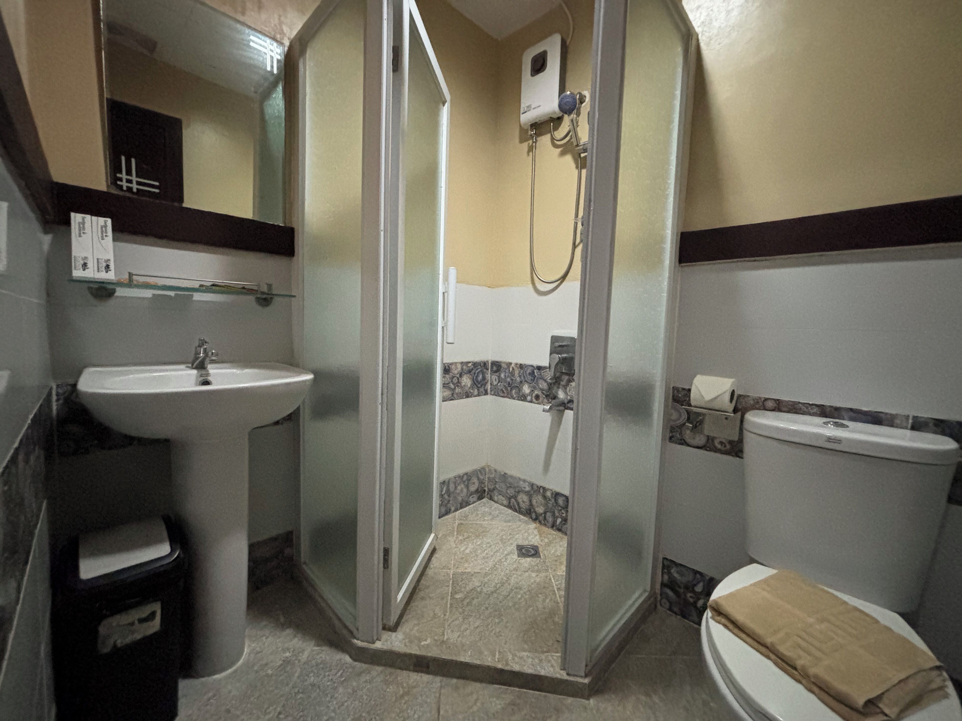 Ein Badezimmer mit Waschbecken, Toilette und Dusche, einschließlich einer Duschkabine.
