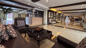 A spacious lobby with a reception desk, seating area, and decorative elements like a chandelier and wall art. - D' Leonor Inland Resort And Adventure Park (Davao)