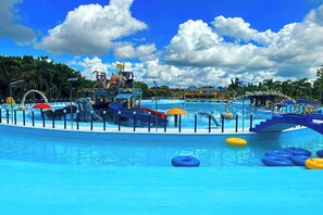 A water park with a large pool, slides, and inflatable rings. - D' Leonor Inland Resort And Adventure Park (Davao)