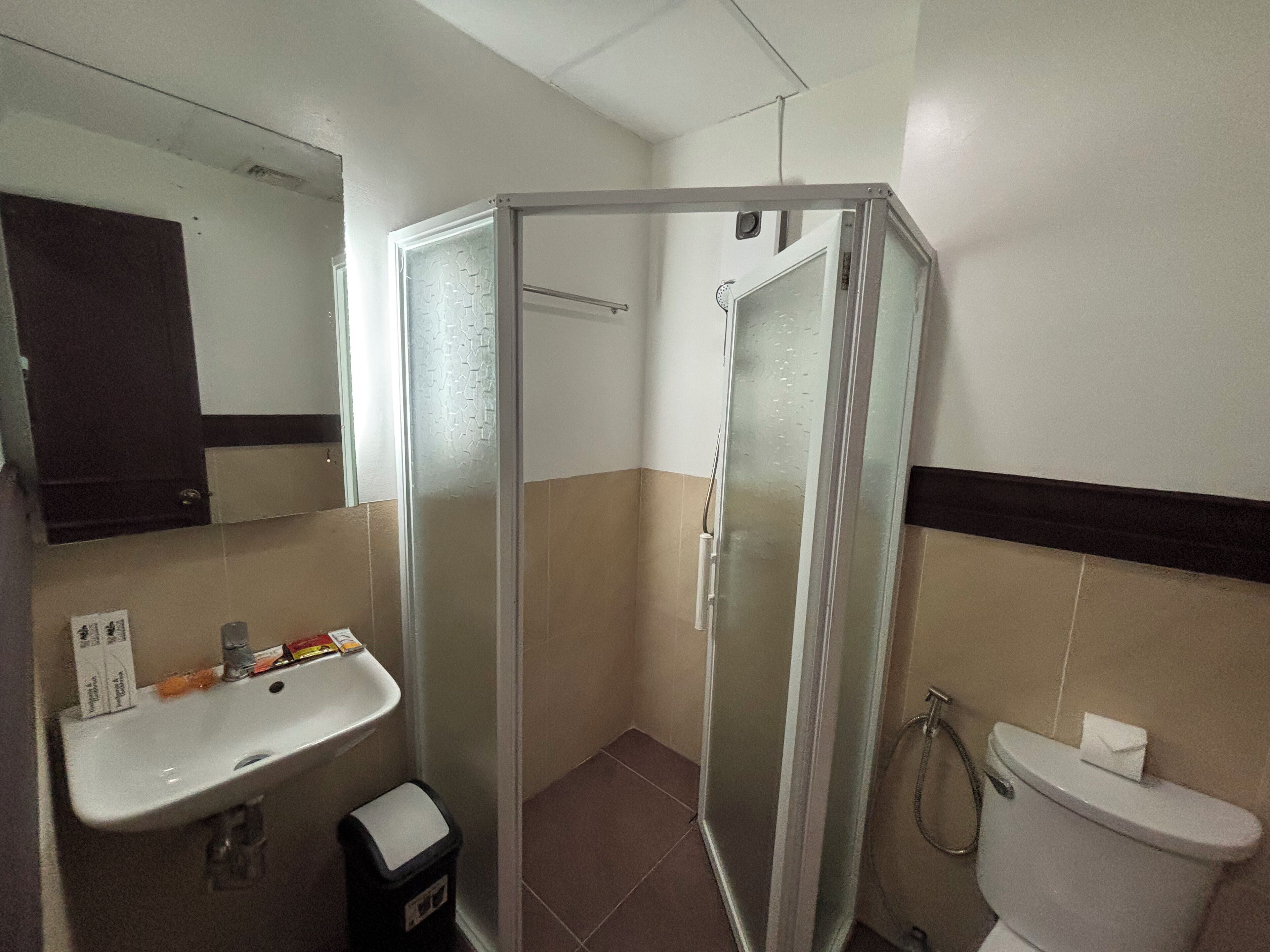 Ein Badezimmer mit Dusche, Waschbecken und Toilette.