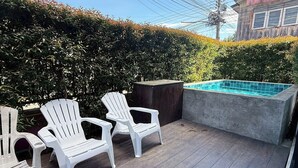 Una terraza con dos sillas Adirondack y una piscina pequeña.