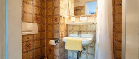 A bathroom with a toilet, sink, and shower curtain.