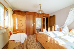 A wooden room with a bed, a chair, and a wardrobe. - Apartment 'Himmelreich' with Shared Terrace, Garden and Wi-Fi (Oberharmersbach)
