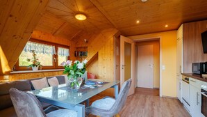 A wooden interior with a dining area, a kitchen, and a staircase. - Apartment 'Sonnenschein' with Shared Terrace, Garden and Wi-Fi (Oberharmersbach)