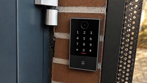 A keypad door lock mounted on a brick wall with a metal door frame. - UNO smart Soltau Wietzendorf (Wietzendorf)