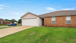 A single-story house with a garage and a brick exterior. - 3 KING BEDS Furr-Friendly Fayetteville Retreat (Fayetteville)