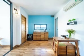 A modern kitchen with wooden cabinets, a window, and a built-in air conditioner. - Sea Vista Boutique Hotel & Apartment By Haviland (Da Nang)