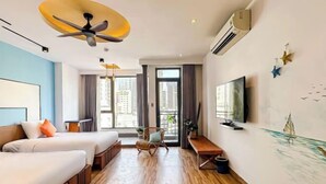 A hotel room with two beds, a desk, a chair, a ceiling fan, an air conditioner, a TV, and a large window with curtains. - Sea Vista Boutique Hotel & Apartment By Haviland (Da Nang)