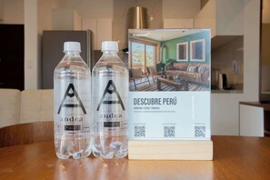 Dos botellas de agua y un folleto de 'Descubre Perú' sobre una mesa de madera.