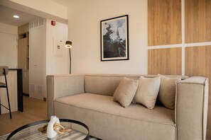 A modern living room with a beige sofa, a framed abstract painting, and a floor lamp. - w* | Enchanting 1BR w/ Balcony in Barranco (Barranco)