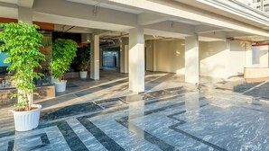A spacious indoor area with tiled flooring and potted plants.