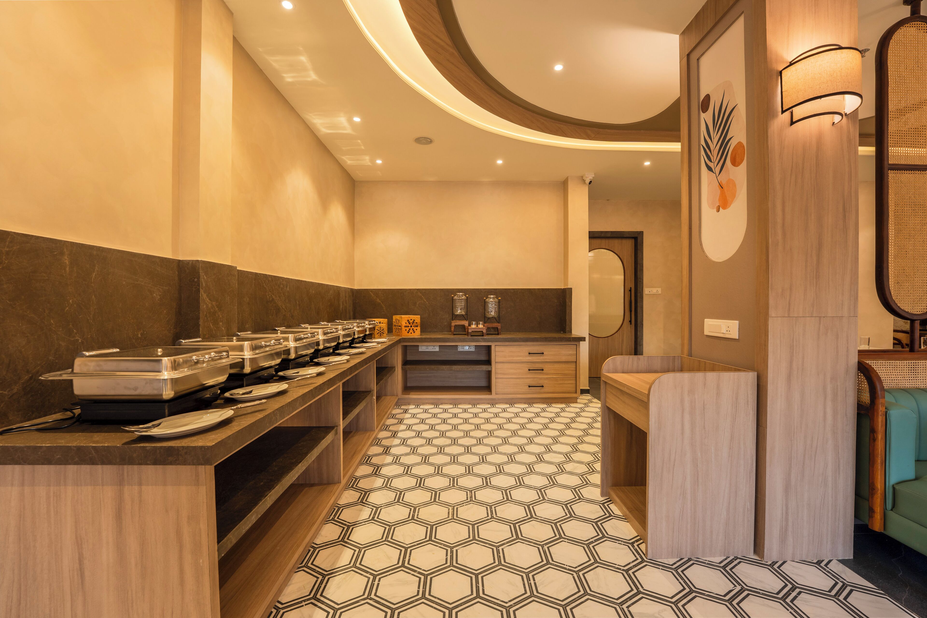 A modern bathroom with a geometric patterned floor, a long counter with multiple sinks, and a mirror with a decorative wall piece.