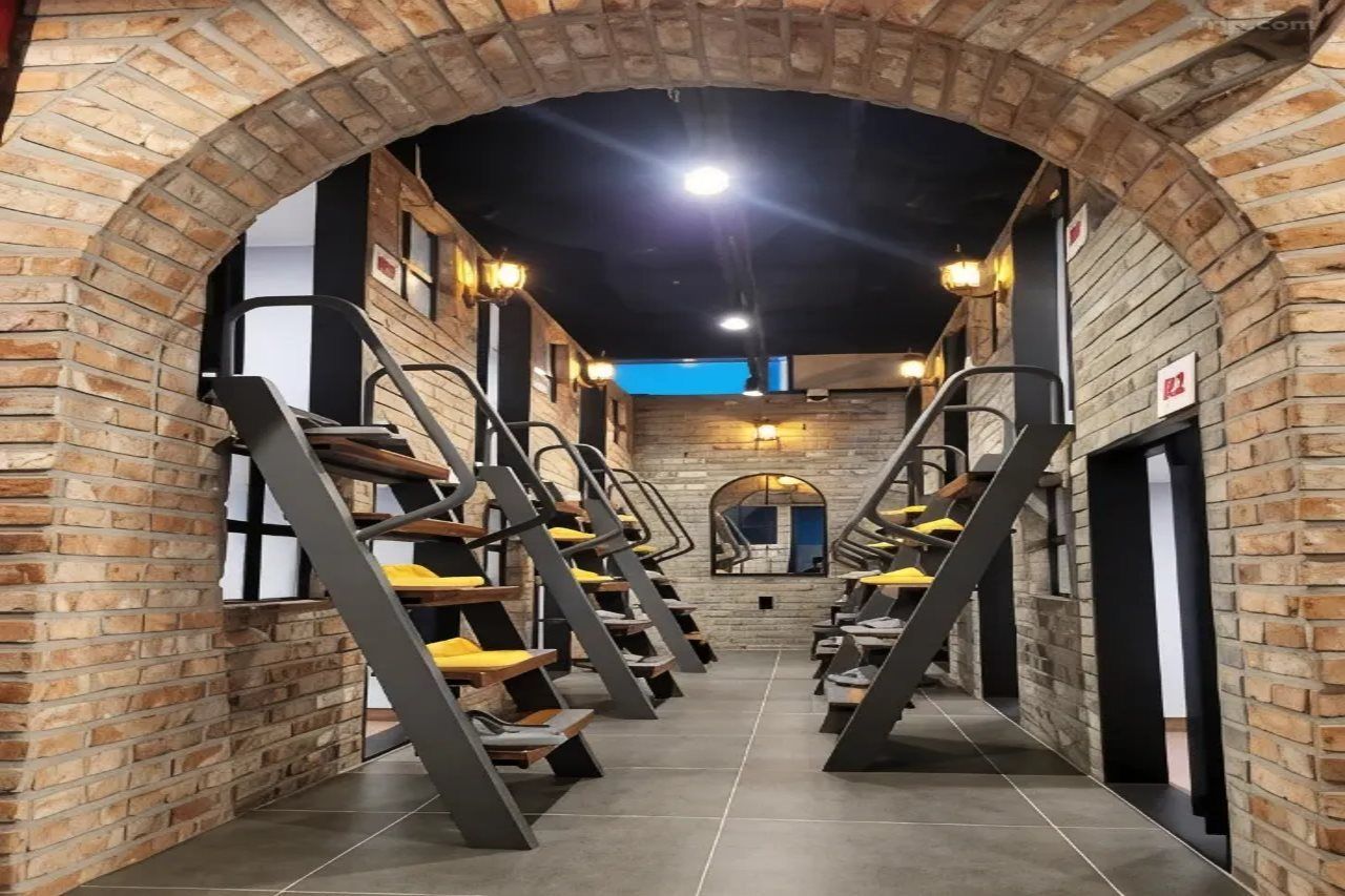 Una escalera en un pasillo de paredes de ladrillo con diseño moderno, que conduce a un nivel superior.