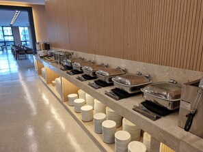 A buffet setup with multiple serving stations and stacked plates. - Sota Suite Yangyang Granbay (Yangyang)