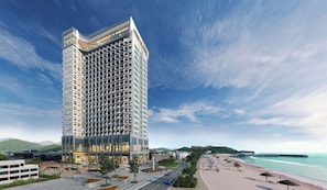 A modern high-rise hotel with a unique facade, situated by a beach with a promenade and a pier. - Sota Suite Yangyang Granbay (Yangyang)