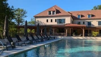 Una piscina al aire libre de temporada, sombrillas, tumbonas