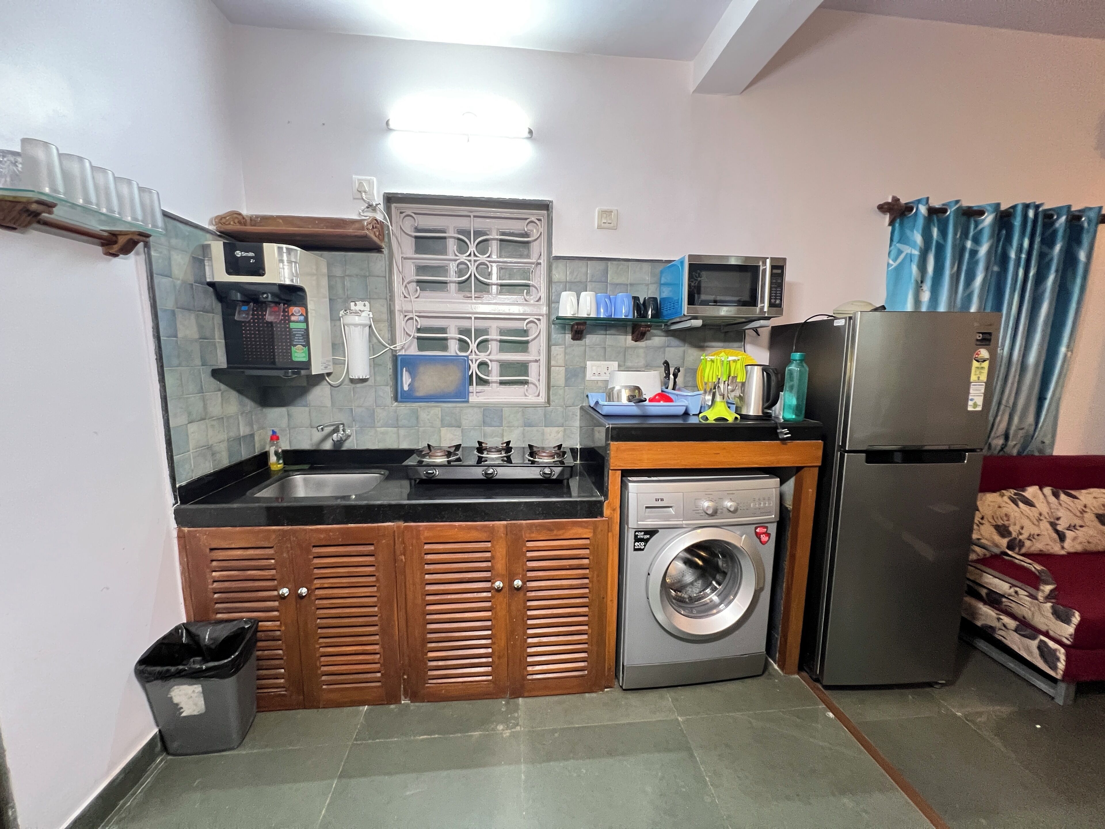 Cocina compacta con estufa a gas, microondas, lavadora y refrigerador.