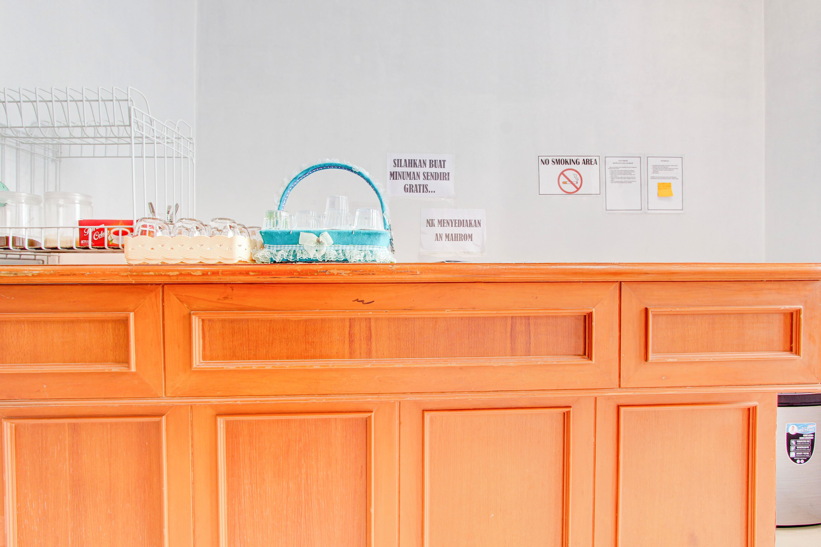 A kitchen counter with a coffee machine, a dish rack, and a sign indicating a smoking area.