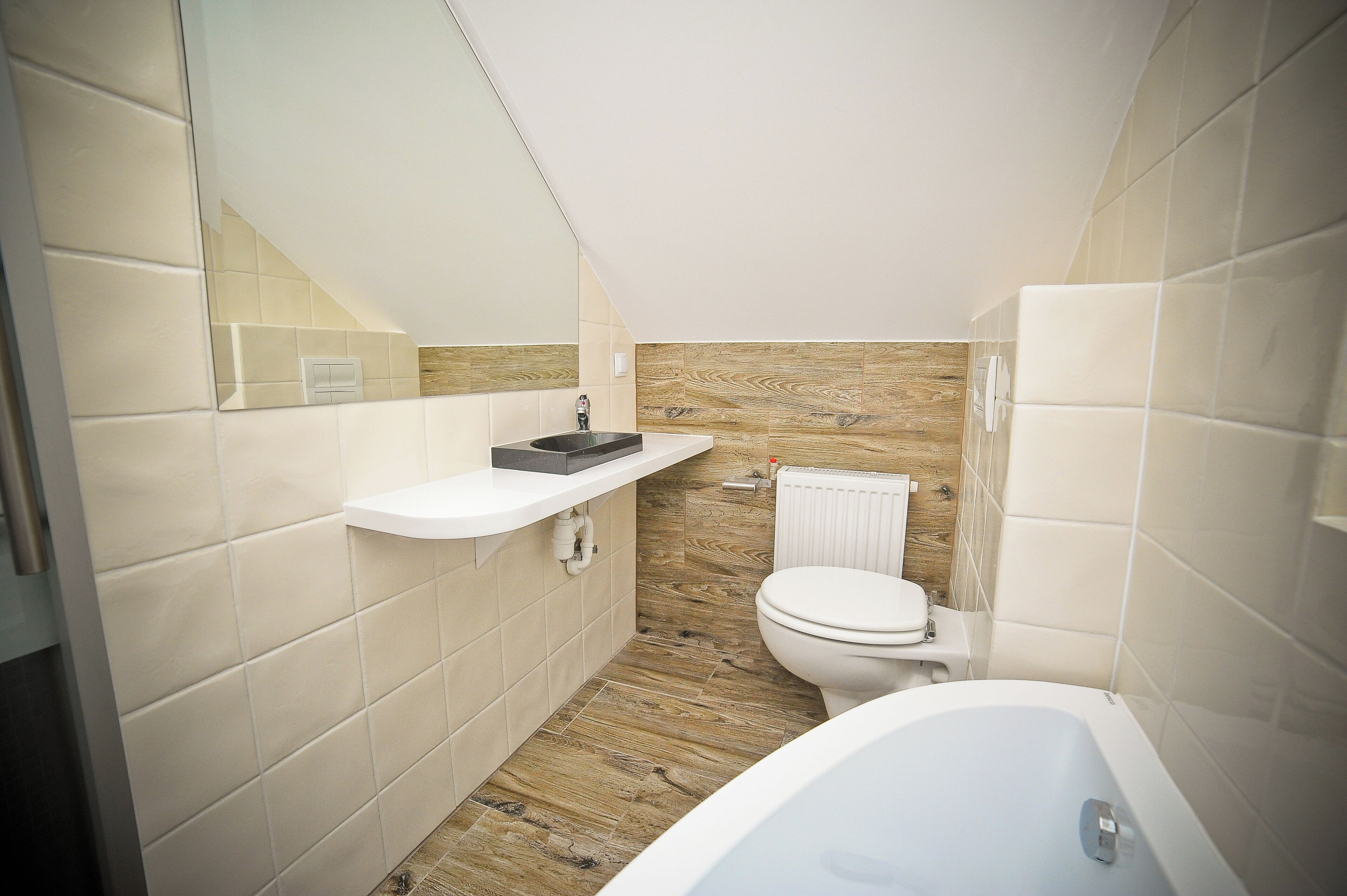 A compact bathroom with a white sink, a toilet, and a bathtub.