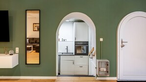 A compact kitchen with white cabinets, a built-in oven, and a sink.