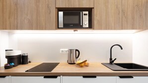 Eine Küche mit Mikrowelle, Kaffeemaschine, Wasserkocher und Spüle.