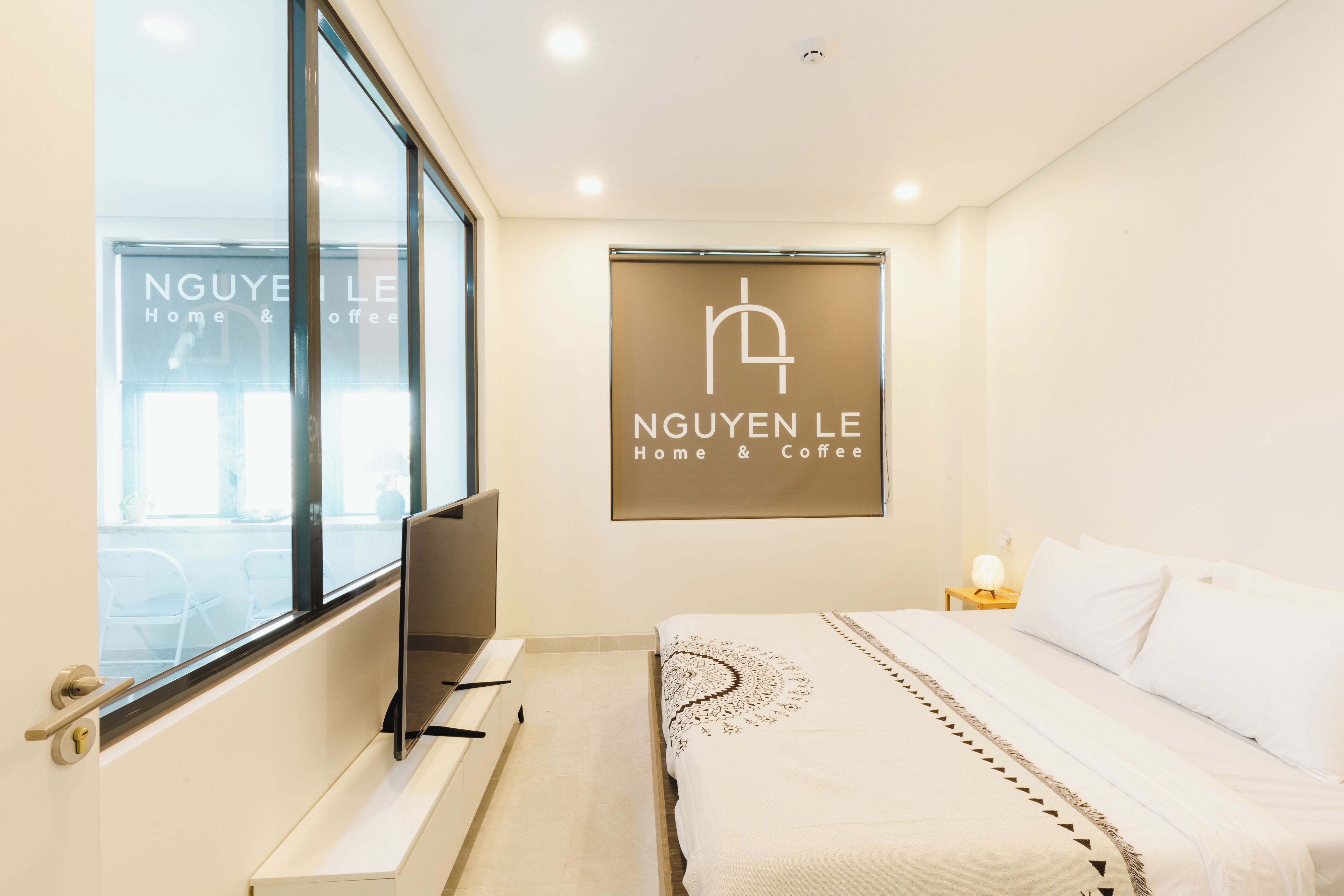 Une chambre d’hôtel avec un lit, un bureau, une chaise, une télévision et une fenêtre.