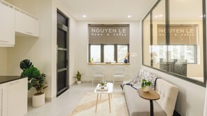 A modern interior with a sofa, a small table, and a window with a view. - Nguyen Homestay Phan Ton - District 1 (Ho Chi Minh City)