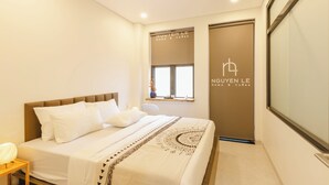 A modern hotel room with a neatly made bed, a bedside table with a lamp, and a window with a view. - Nguyen Homestay Phan Ton - District 1 (Ho Chi Minh City)