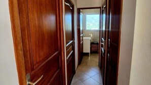 Un couloir avec des portes en bois donnant sur un espace cuisine.