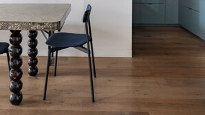 Una cucina moderna con una parete grigio scuro, un armadietto grigio chiaro e una lampada a sospensione.
