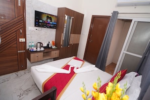 A hotel room with a bed, a TV mounted on the wall, a desk with a chair, and a wardrobe. - Hotel Stay Bliss Marathahalli (Marathahalli, Bengaluru)