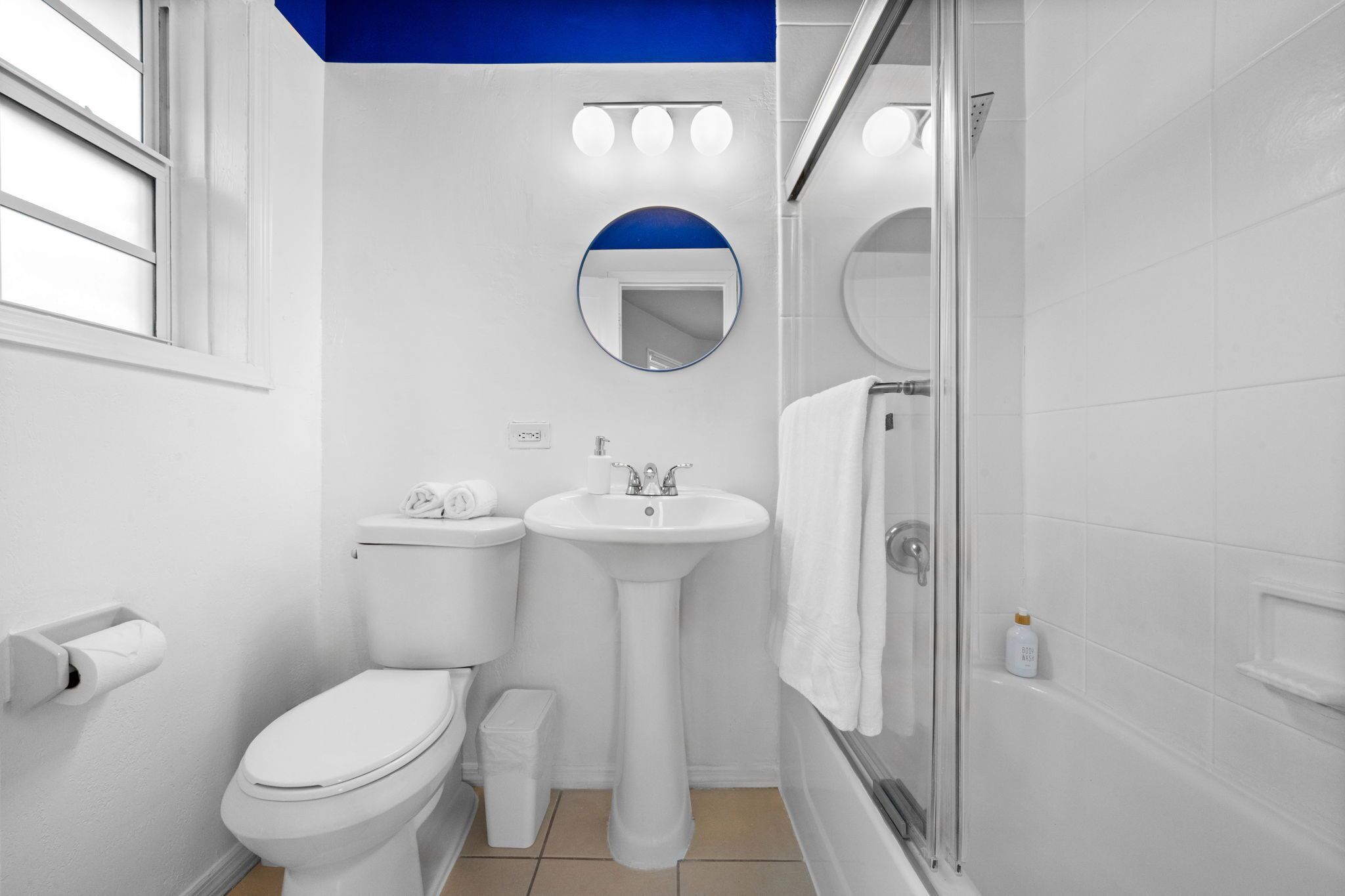 A modern bathroom with a toilet, sink, and shower.