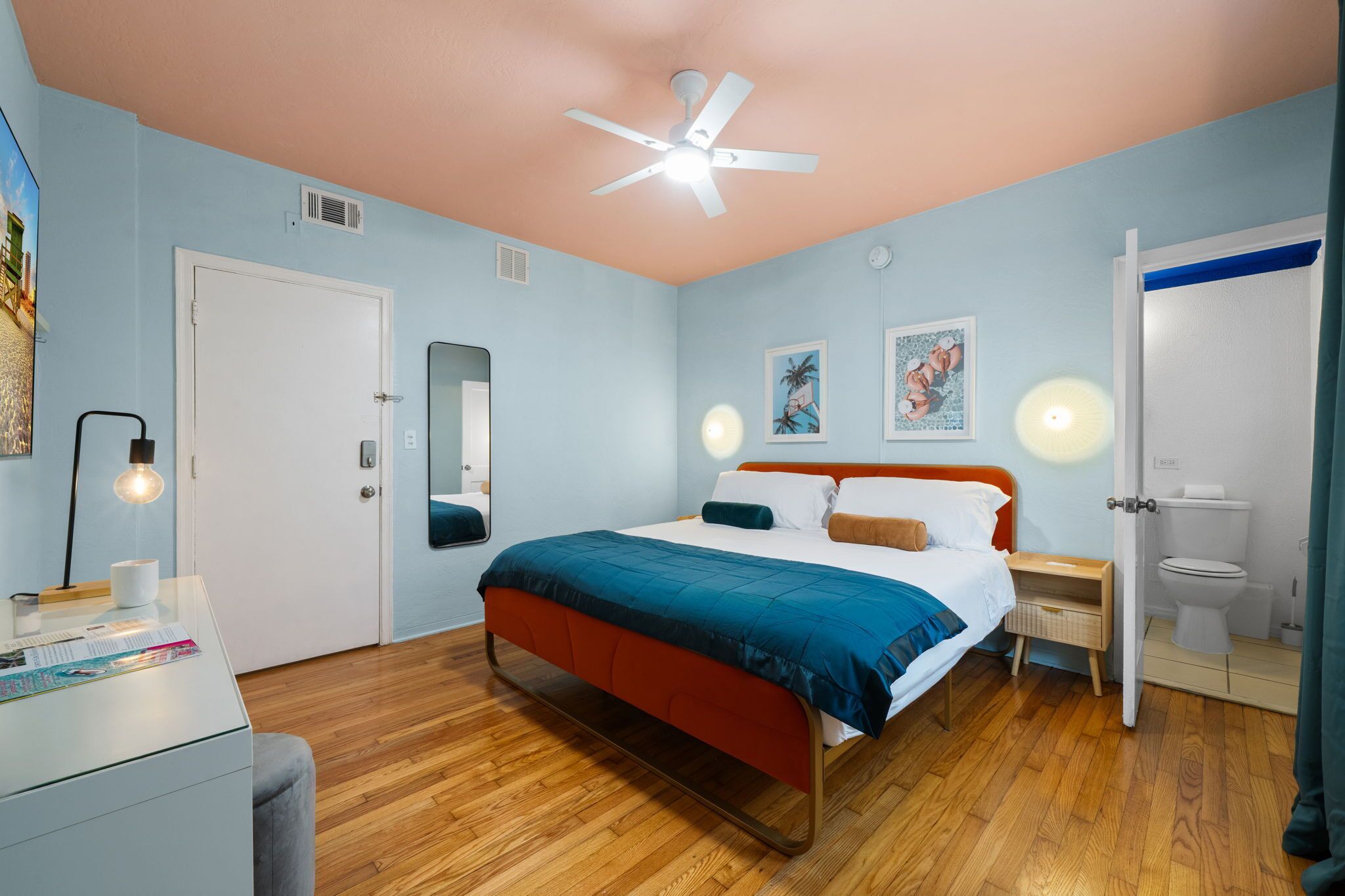 Un dormitorio con cama, mesita de noche y ventilador de techo.