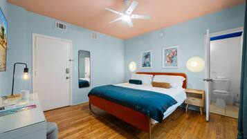 Un dormitorio con cama, mesita de noche y ventilador de techo.