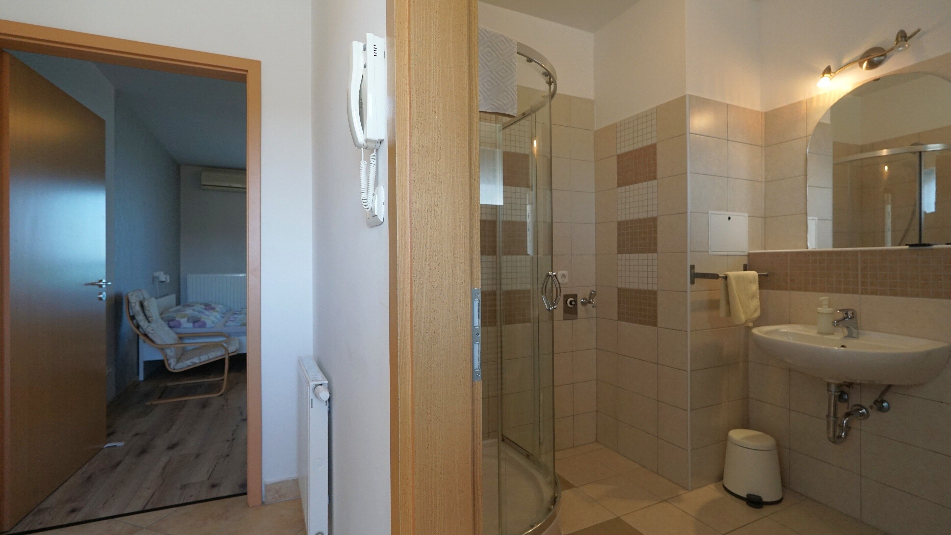 Une salle de bain avec une douche en verre, un lavabo et des toilettes.