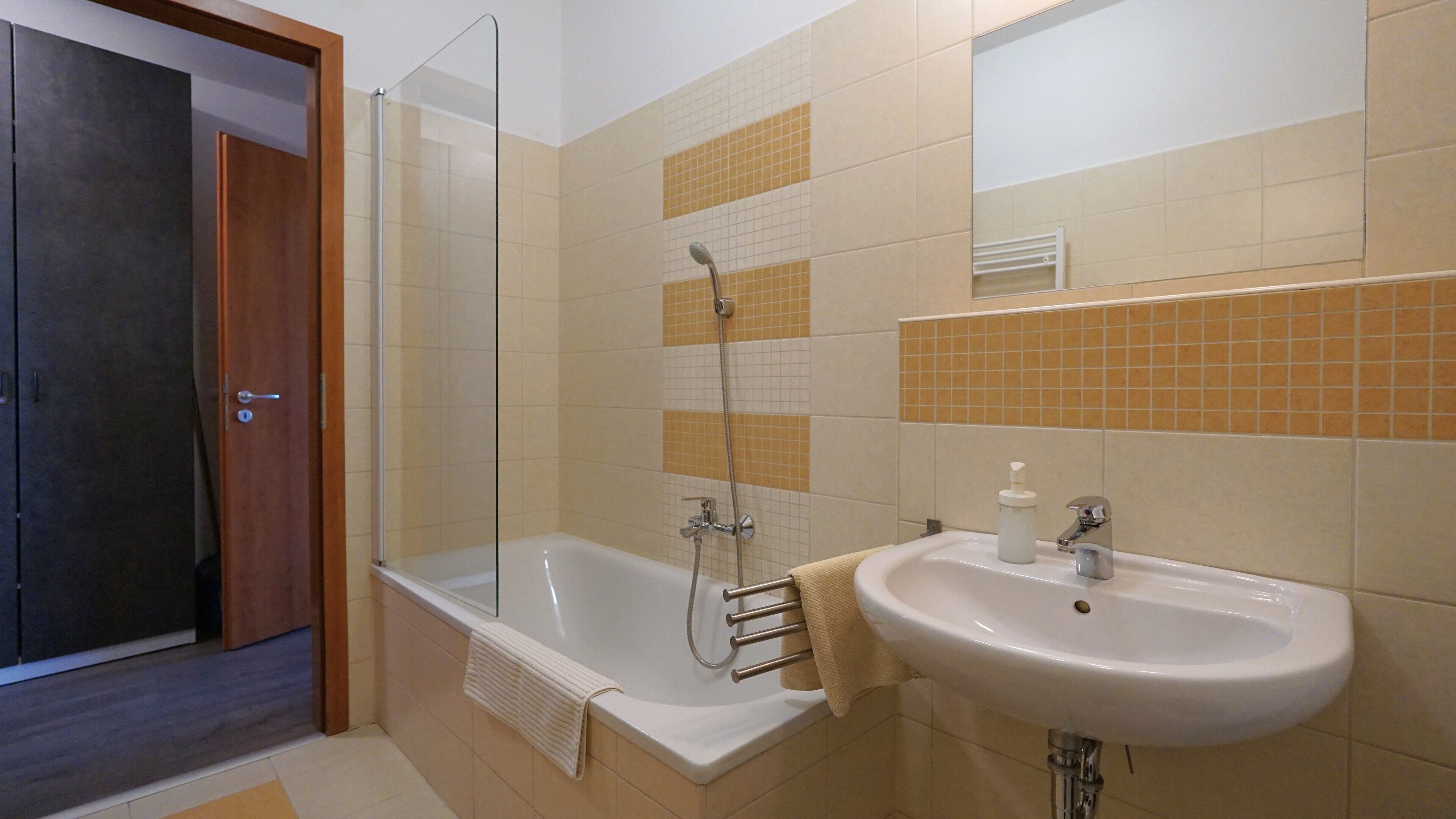Une salle de bain avec une douche, une baignoire et un lavabo.