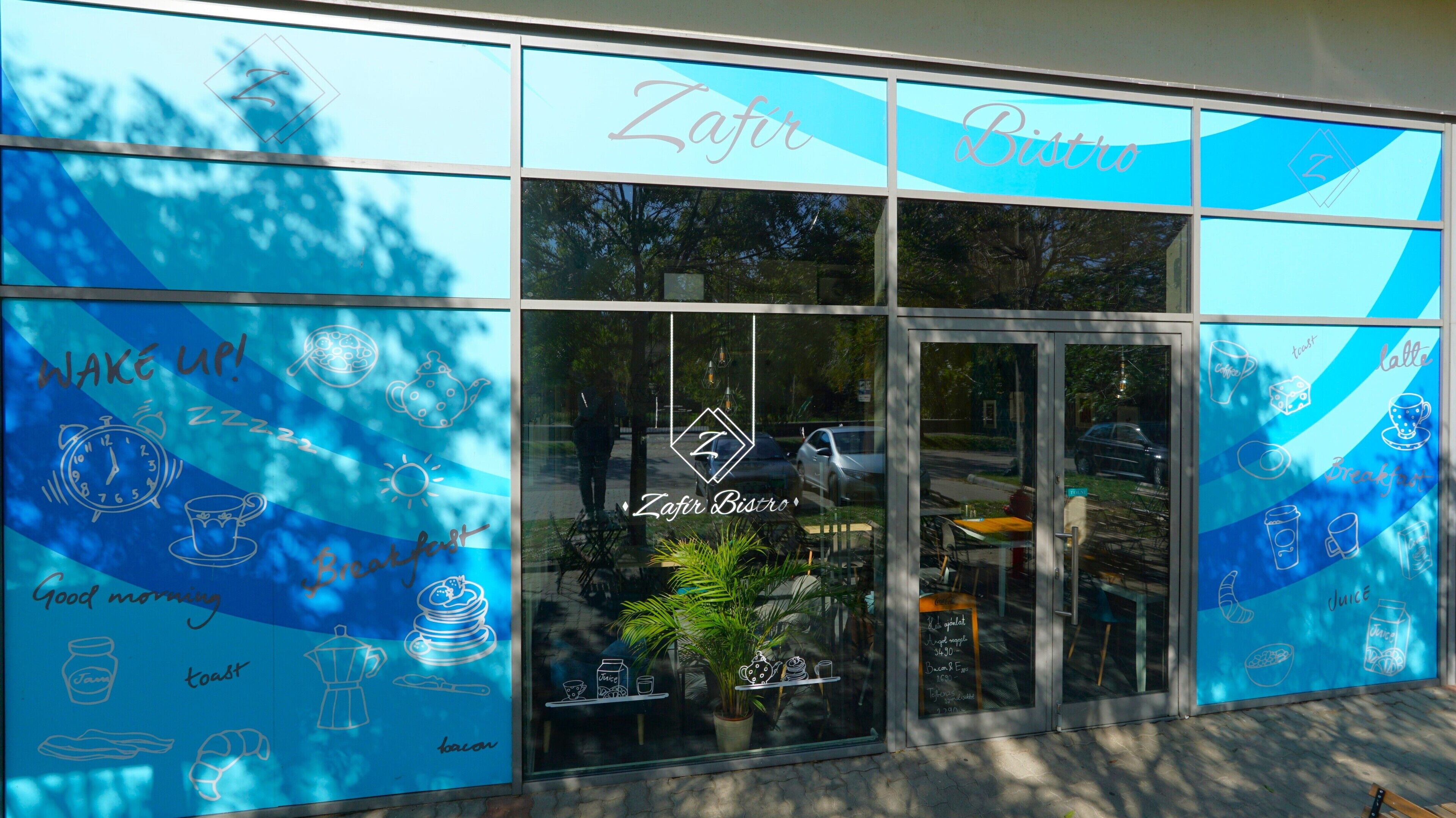 A storefront with a blue awning and glass doors, featuring the name 'Zafir Bistro' and various food-related illustrations.
