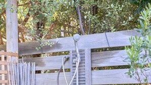 En træpergola med metalstige og et springvand.