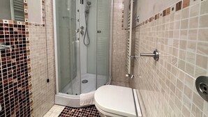 A bathroom with a glass-enclosed shower, a toilet, and tiled walls. - Tuscan accommodation (20 minutes from Florence) (Prato)