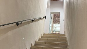 A staircase with a metal handrail, white walls, and exposed wooden beams. - Tuscan accommodation (20 minutes from Florence) (Prato)