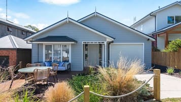 A single-story house with a covered patio, a fenced garden area, and a visible garage door.