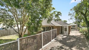 A residential property with a fenced yard, a detached garage, and a house with a tiled roof. - Beach Breeze Bungalow - in the heart of Torquay (Torquay)