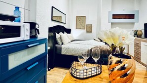 A modern bedroom with a bed, a dresser, a coffee maker, and a vase with flowers. - Comfort Studio Apt Near Klosterneuburg (Klosterneuburg)