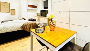 A modern, well-lit room with a wooden dining table, a sofa, and a bed. - Comfort Studio Apt Near Klosterneuburg (Klosterneuburg)