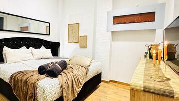 Une chambre à coucher moderne avec un grand lit, une armoire en bois et un miroir au mur.