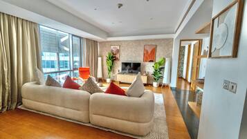 Premium-Apartment, Stadtblick | Wohnbereich | 80-Zoll-Smart-TV mit Digitalempfang