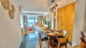 A modern dining area with a round table, chairs, and a decorative rug. - Premium Vacation Home in Old Dubai  (Dubai)