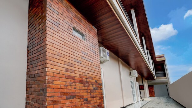 Un bâtiment moderne avec une façade en briques, un toit en bois et un ciel dégagé.