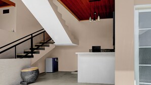 Un intérieur moderne avec un escalier, un comptoir d’accueil et un réfrigérateur.